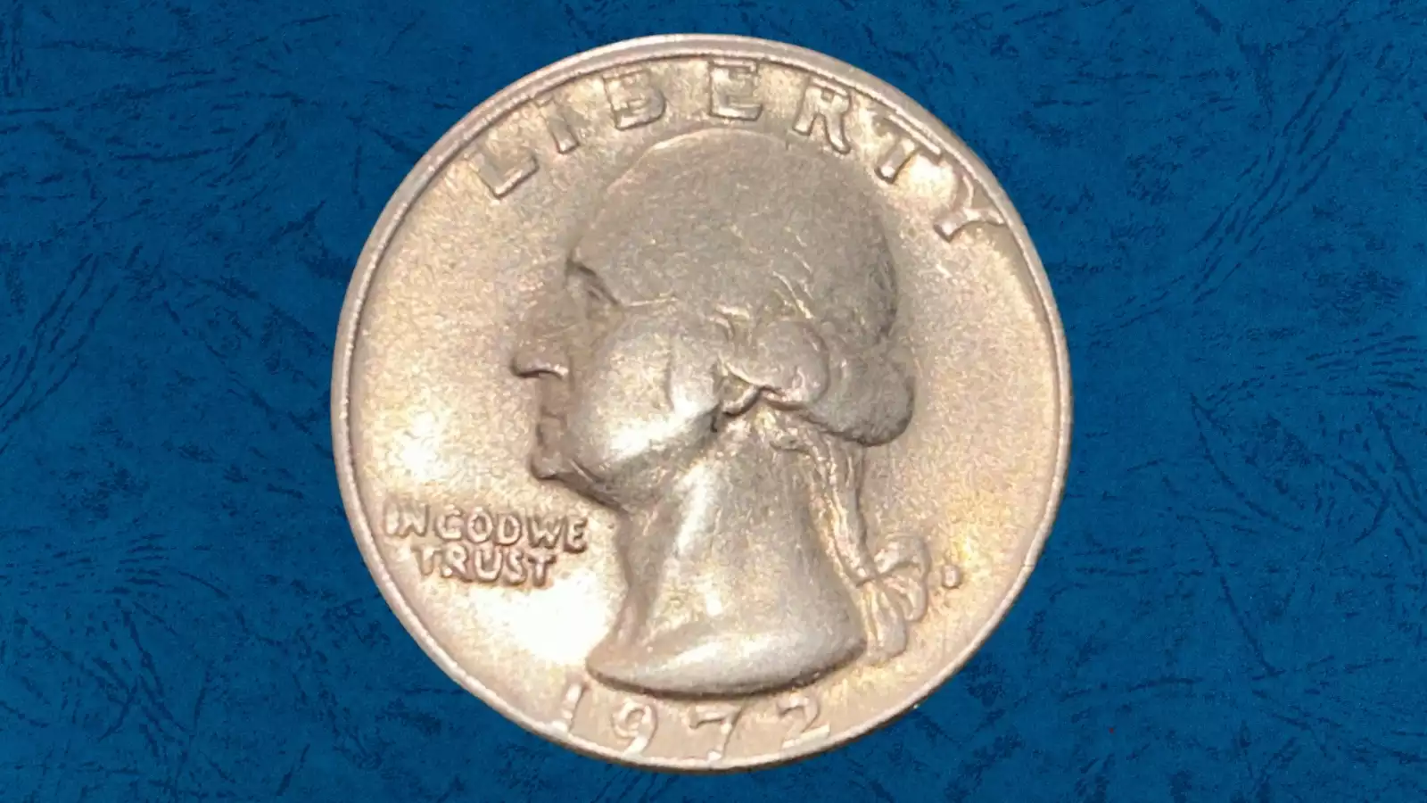1972 Washington quarter off-center strike error showing design shifted with crescent of blank planchet visible